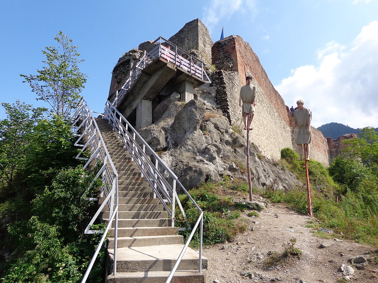 Scara de urcare la donjon, ziduri de piatră și cărămidă, vedere oblică apropiată.