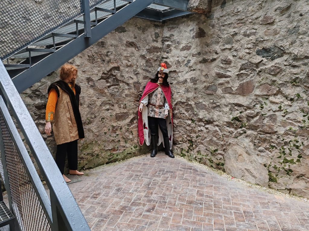 Zidărie de piatră la baza pasarelei metalice, cu amenajări de vizitare.