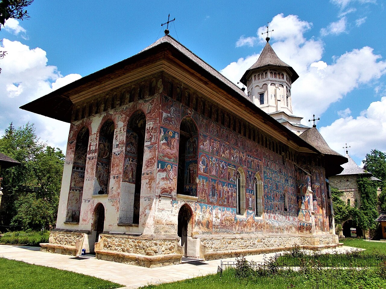 Pridvorul cu arcade, stâlpi, soclu și streașină, vedere oblică.