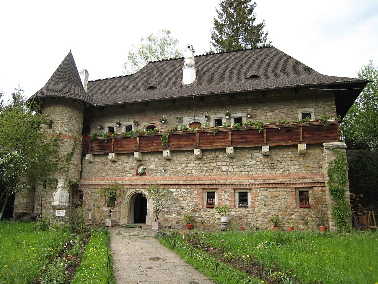 Clisiarnița: corpul de piatră, turn circular și galerie de lemn.