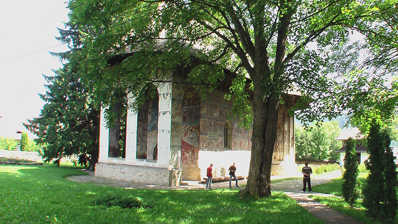 Pridvorul deschis văzut oblic, cu arcade și stâlpi.