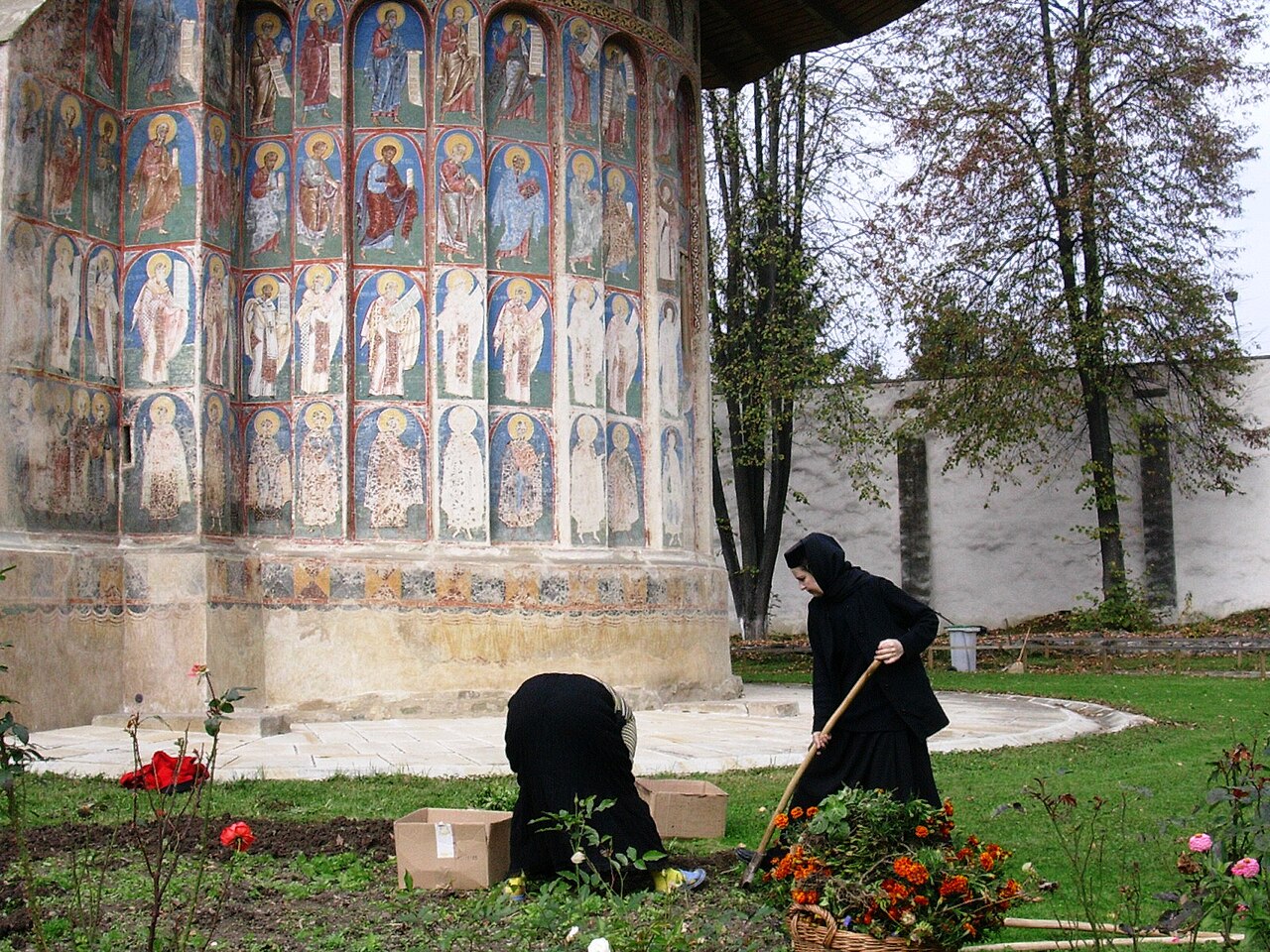 Detaliu al picturii exterioare pe absidă și al soclului de piatră.