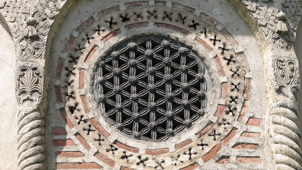 Fereastră circulară cu trafor și ancadrament sculptat.