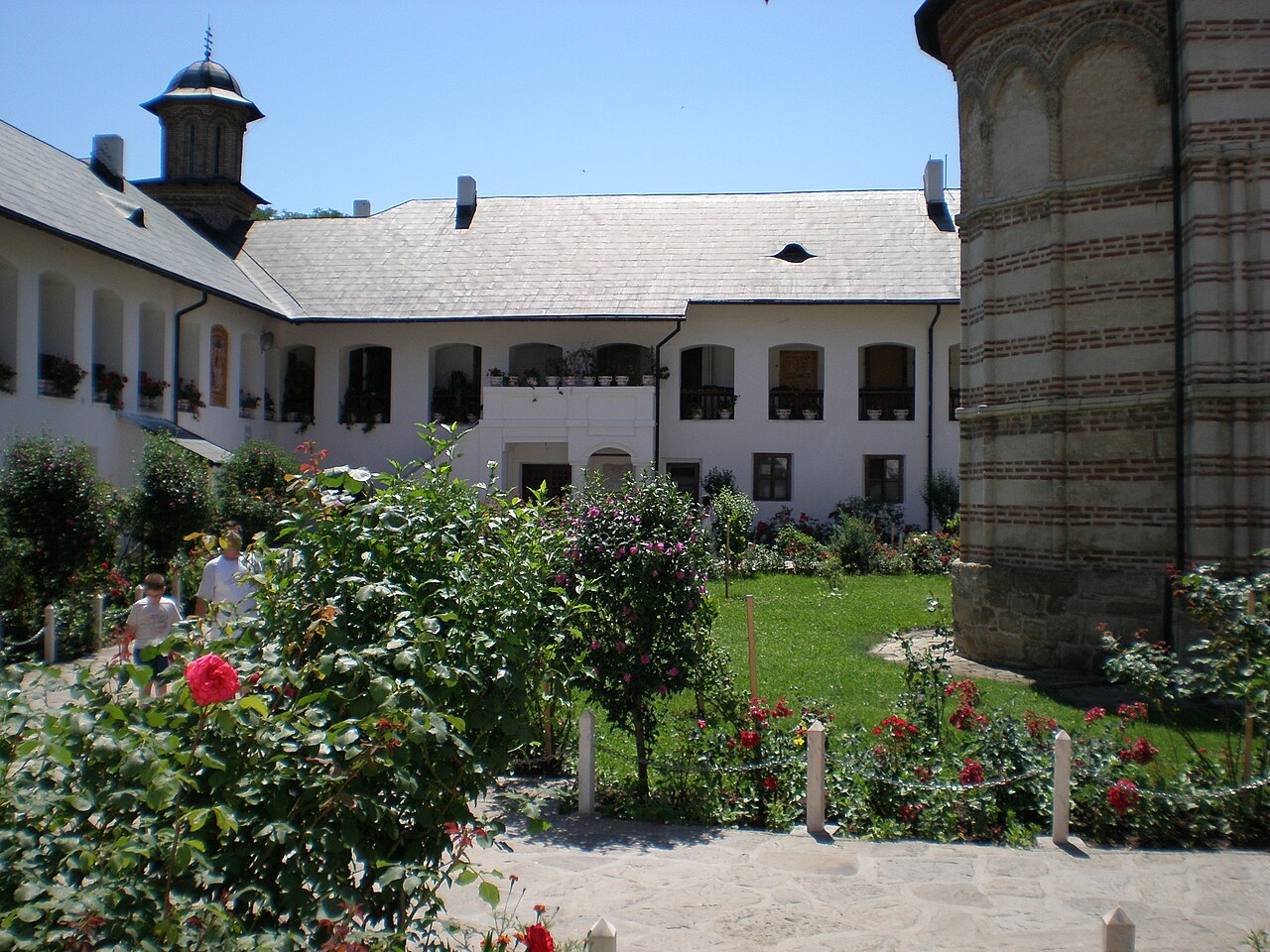 Colțul curții, aripi de chilii și turnul care depășește învelitorile.