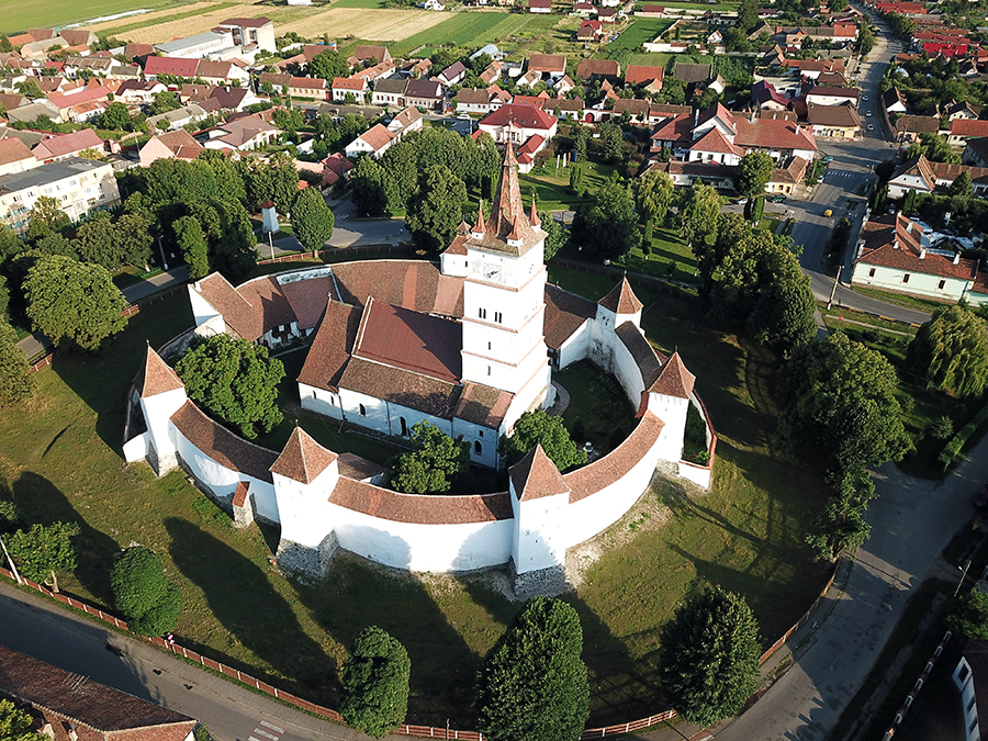 Ansamblu aerian oblic: biserica, incinta, turnurile și învelitorile.