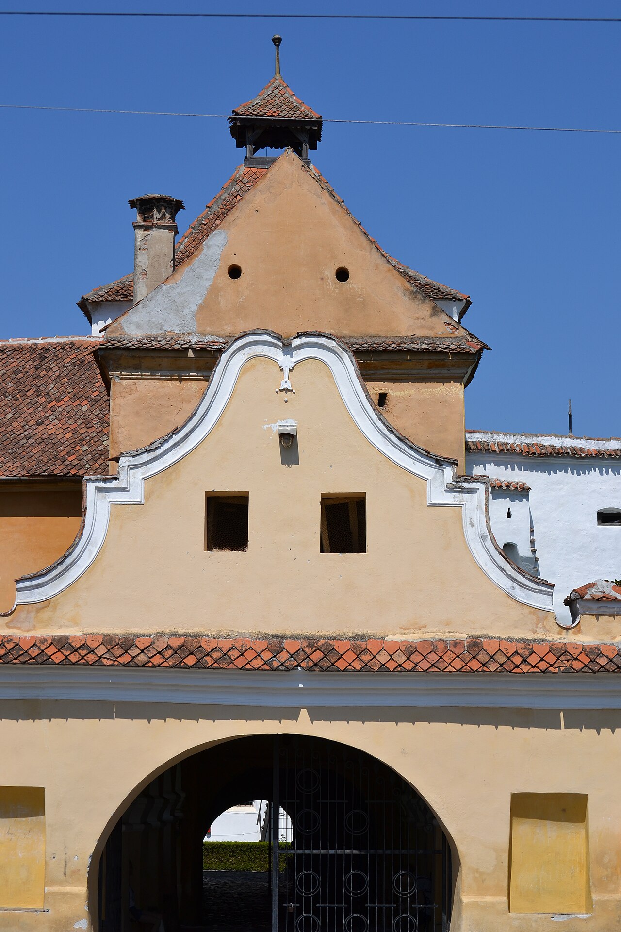 Frontonul curbat al porții, decor și goluri.