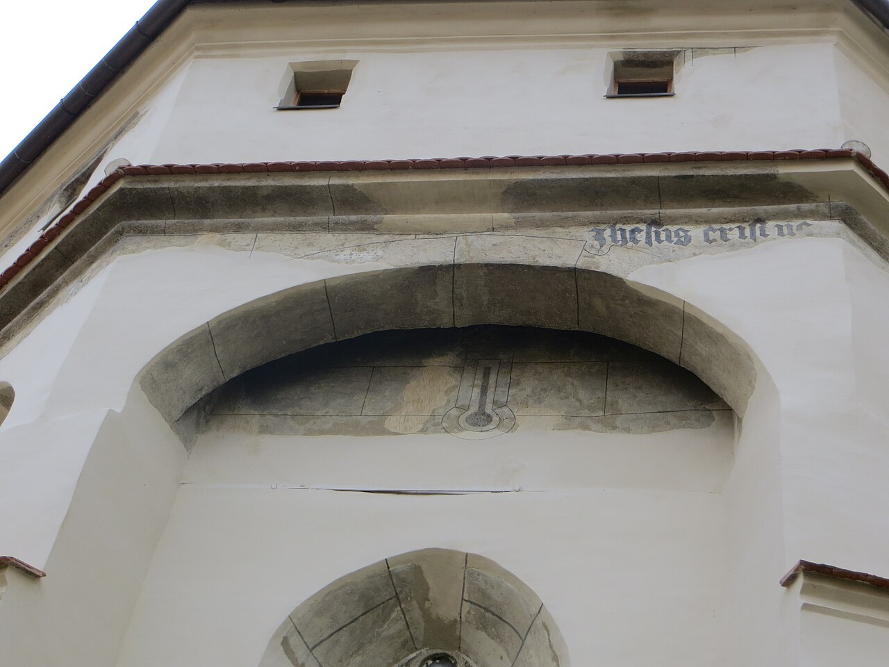 Arcadă și fragmente de inscripție pe zidul exterior.