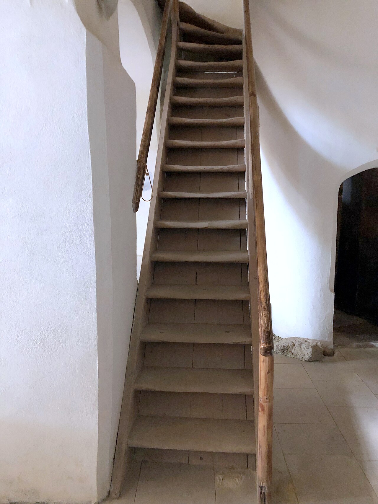 Scară interioară de lemn și zidurile de închidere.