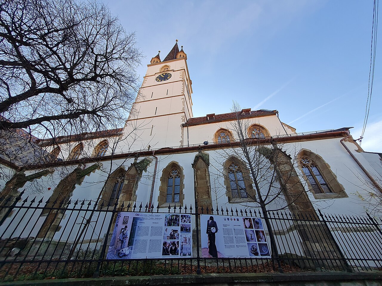 Fațadă lungă cu ferestre înalte, turnul și împrejmuirea, contraplonjeu.