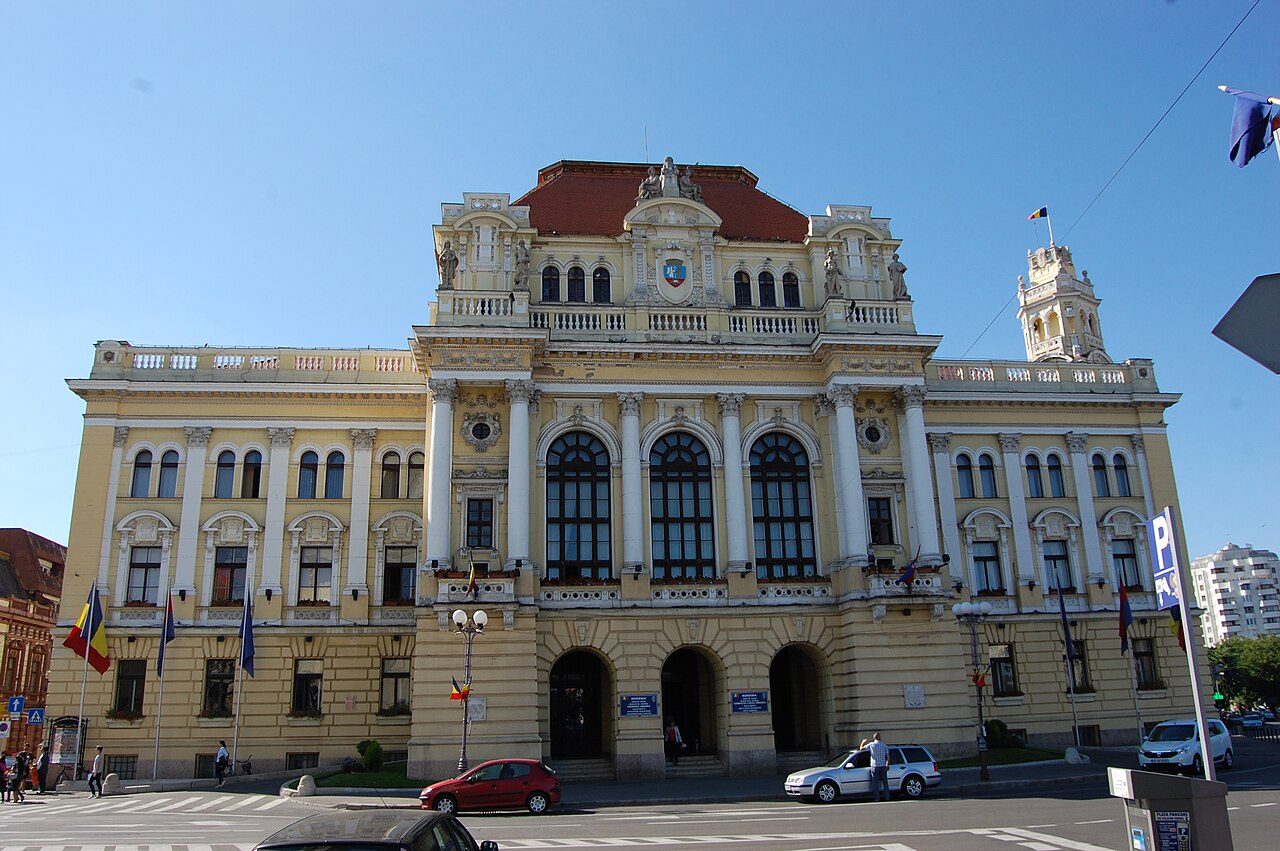 Fațada aproape frontală: travei, arcadele parterului și frontonul central.