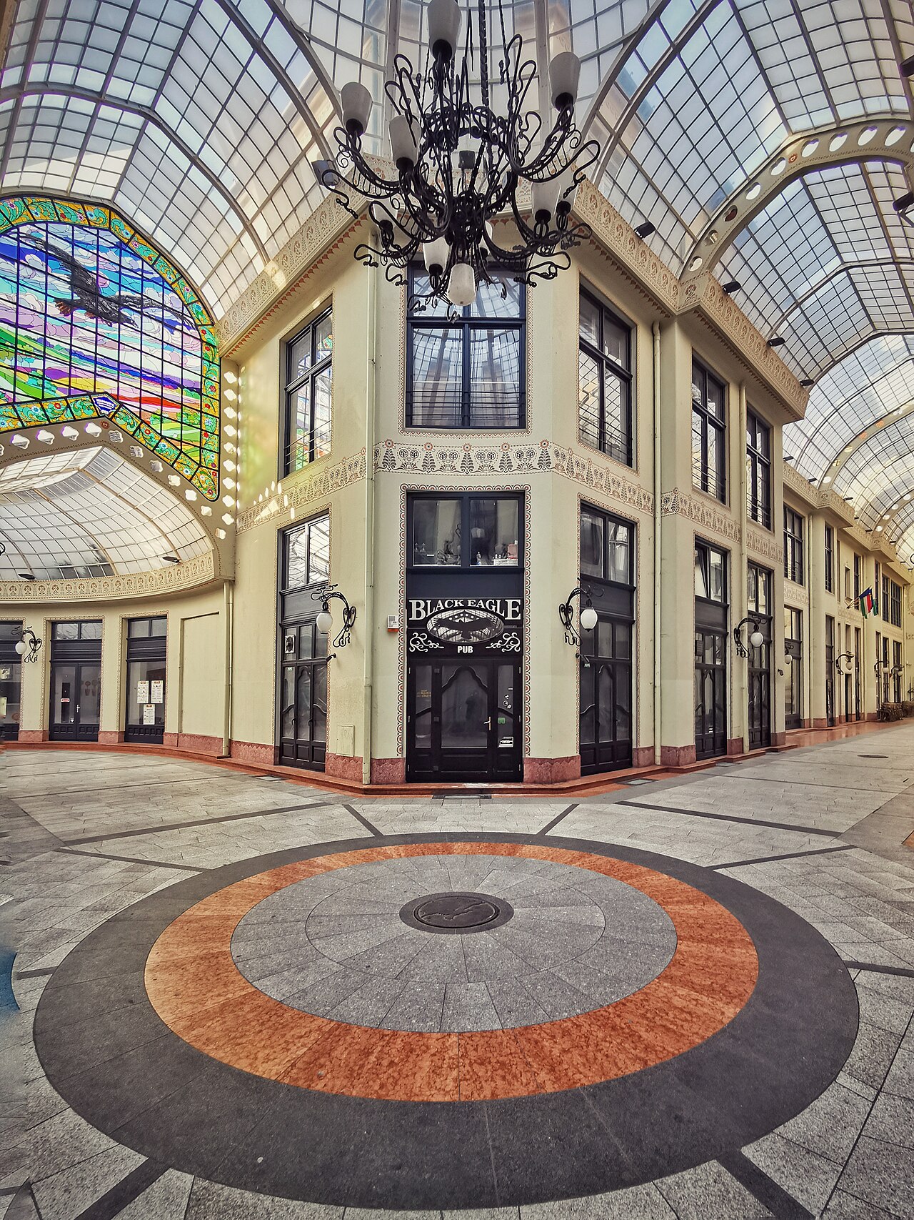 Nodul pasajului, fațadele interioare și desenul circular al pardoselii.