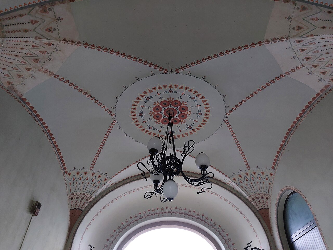 Plafon ornamental pictat al accesului secundar și candelabru.