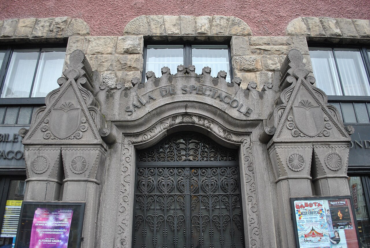 Portal sculptat cu ușă metalică ornamentală, în vedere apropiată.