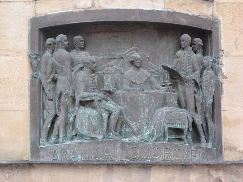 Alt relief exterior cu personaje și decor arhitectural.