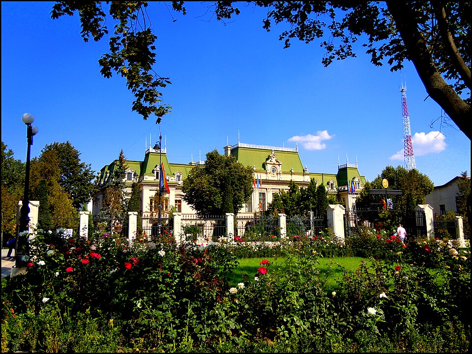 Ansamblul palatului dinspre grădină, cu volumele acoperișului și aripi; arborii ascund parterul.