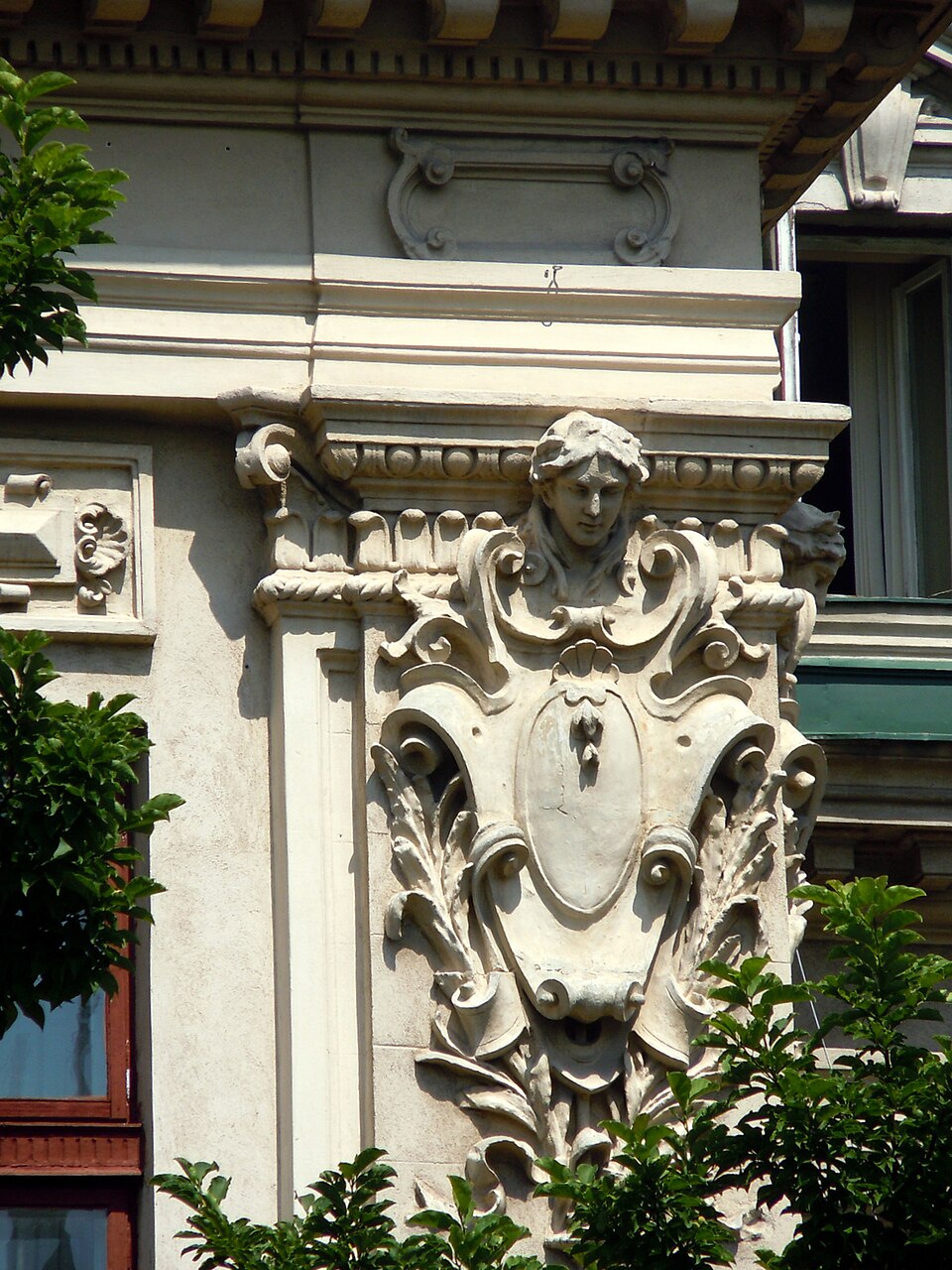 Cartuș și ornament sculptat al fațadei, în vedere apropiată.