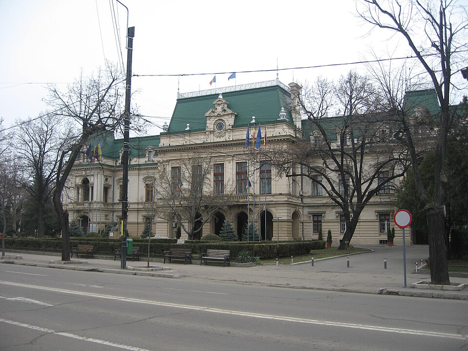 Fațada dinspre stradă în sezon fără frunziș, cu portic și mansardă.