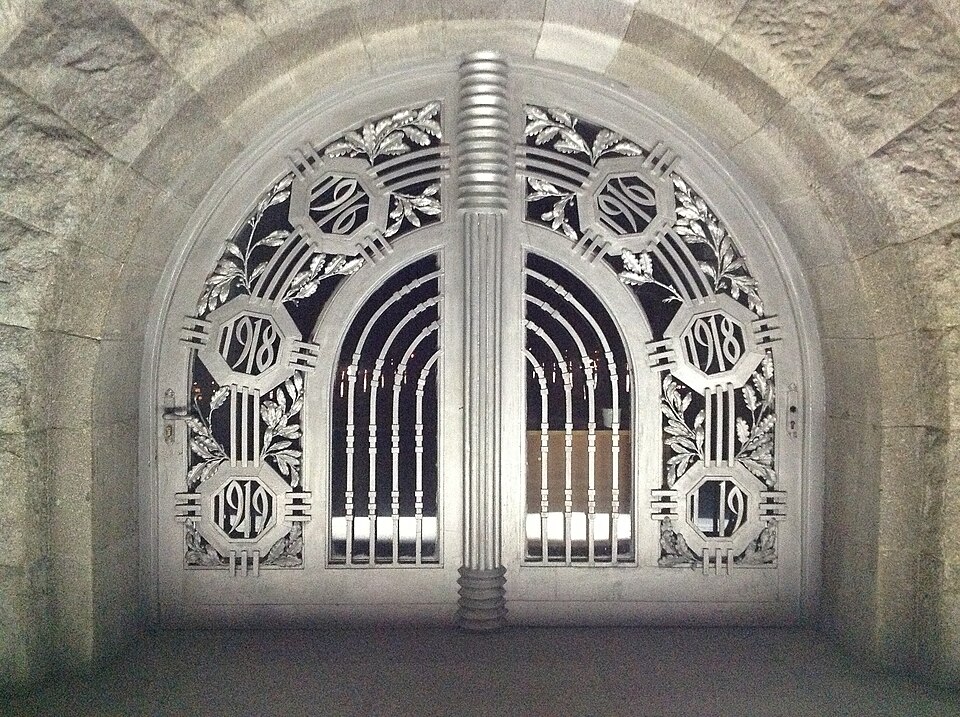 Poarta metalică ornamentală a portalului, cu cercuri și elemente verticale.