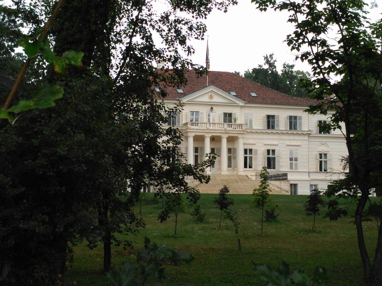 Castelul văzut din parc; vegetația ascunde parțial extremitățile fațadei.