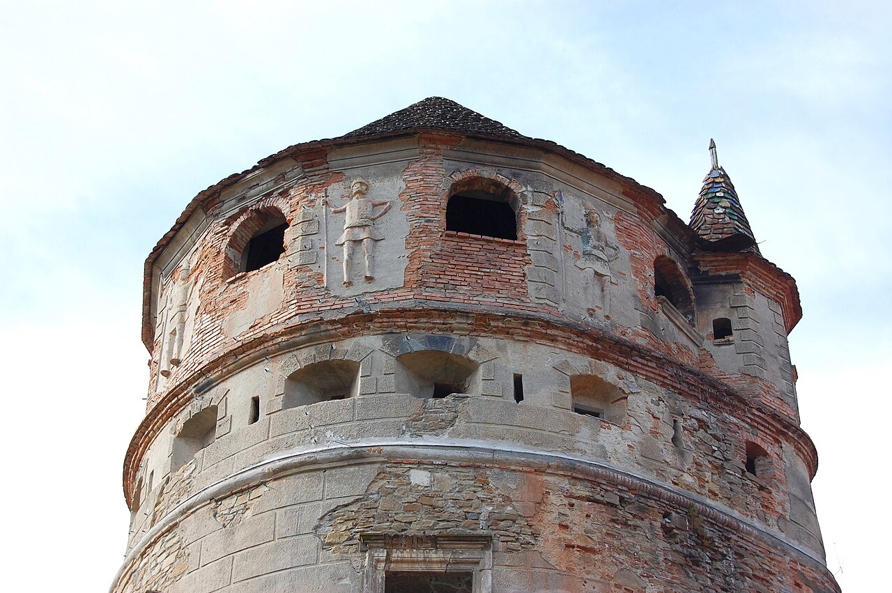 Coronamentul turnului, deschiderile și figurile în relief.