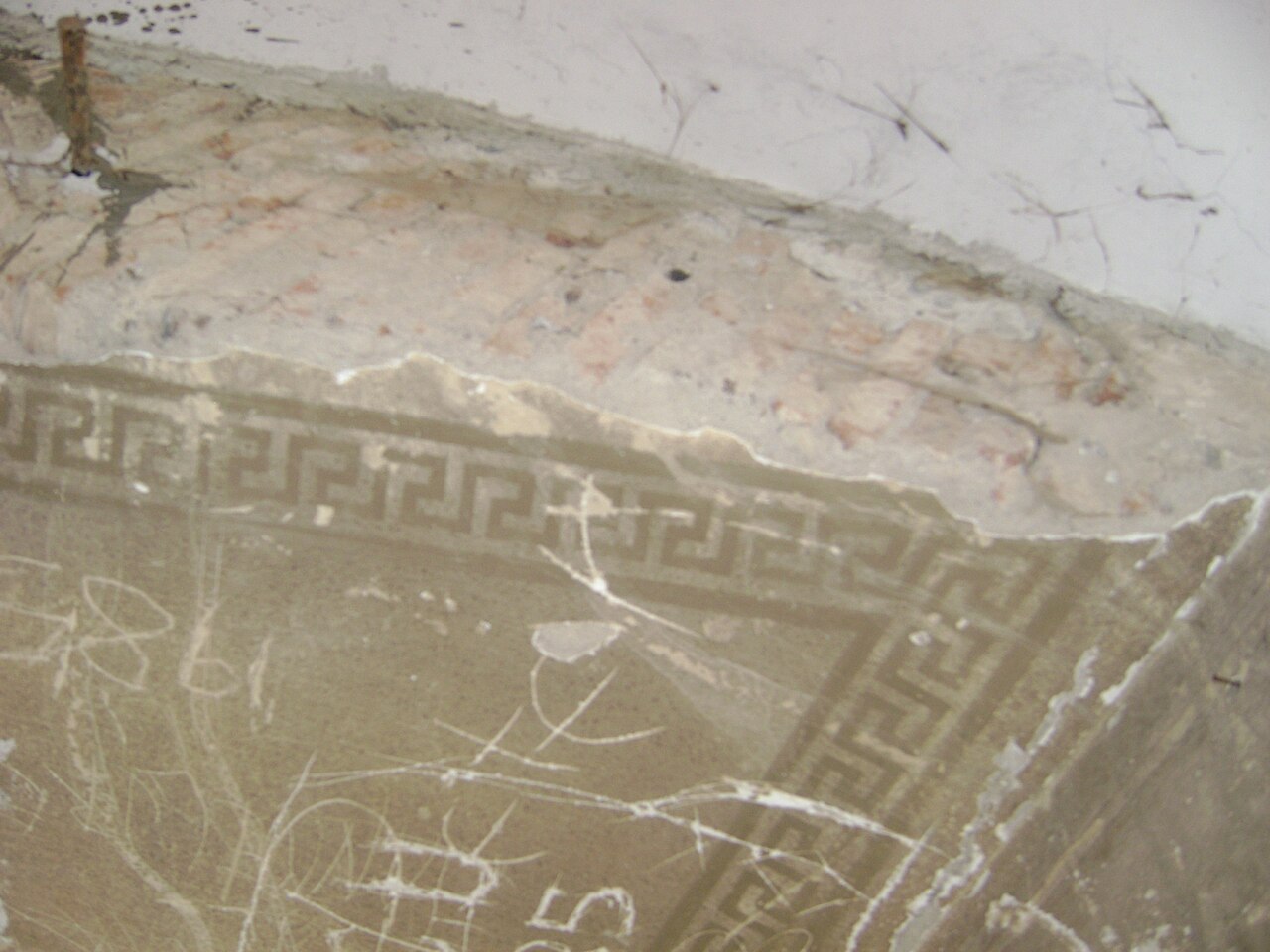 Boltă cu decor geometric și fragment de blazon, în stare degradată.