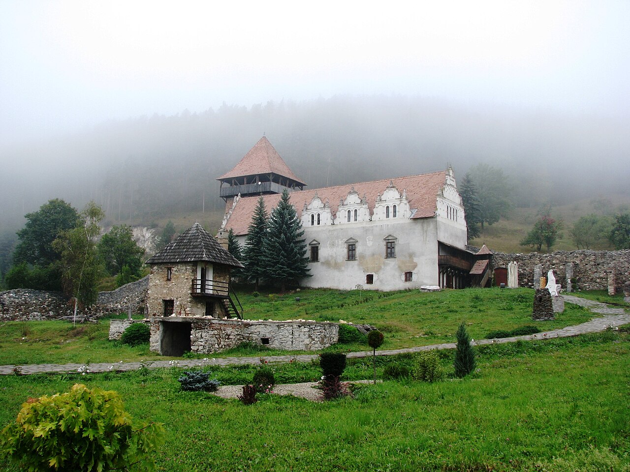 Corpul înalt din curte cu fronton decorativ și scară exterioară.