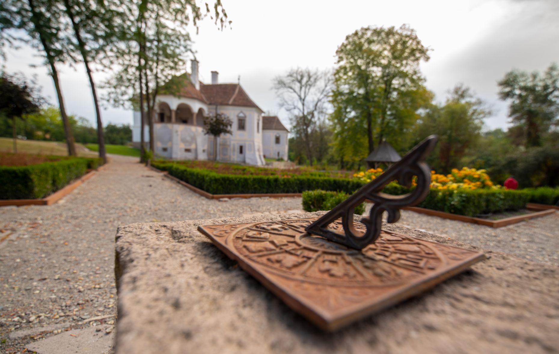 Curtea amenajată, piesă decorativă și castelul în fundal.