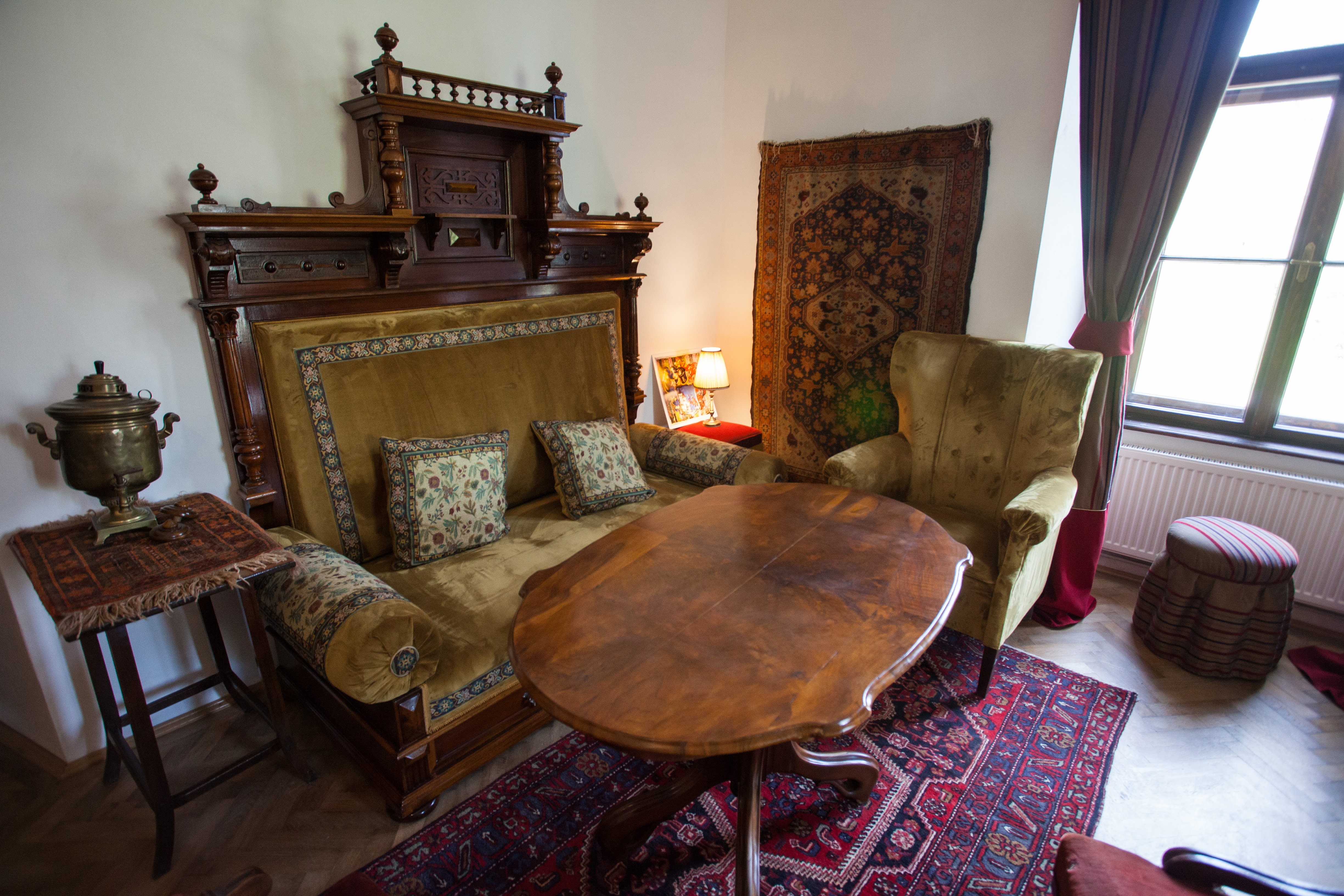 Salon cu mobilier istoric, tavan și pardoseală.