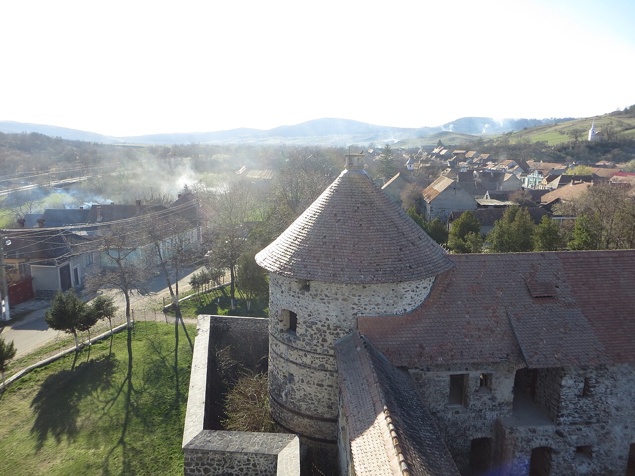 Turn rotund, acoperișul aripii și satul, văzute de la înălțime din castel.