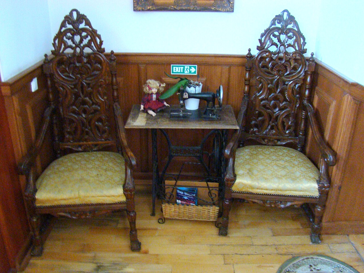 Colț de hol cu lambriu, pardoseală și mobilier hotelier.