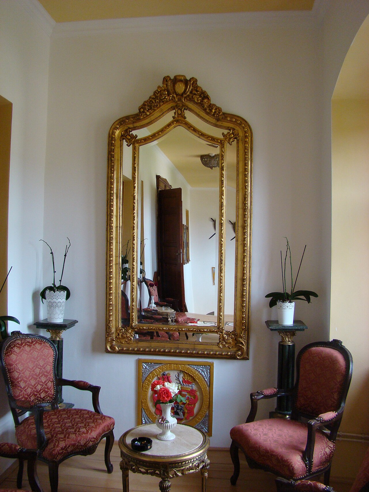 Colțul unui salon: pereți, oglindă și mobilier.