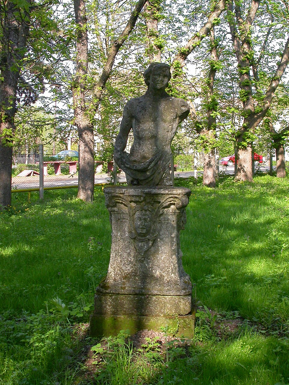 Statuie pe soclu în parcul castelului, reper al amenajării peisagere.