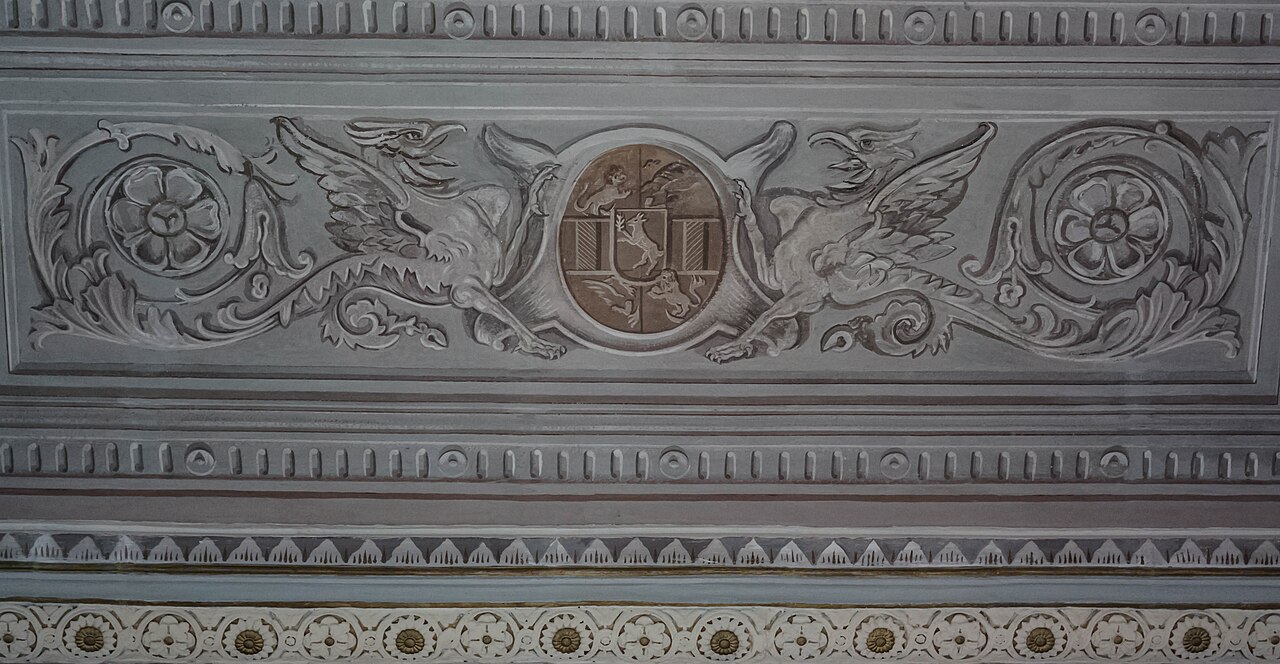 Friză și stucaturi cu blazon în interior.