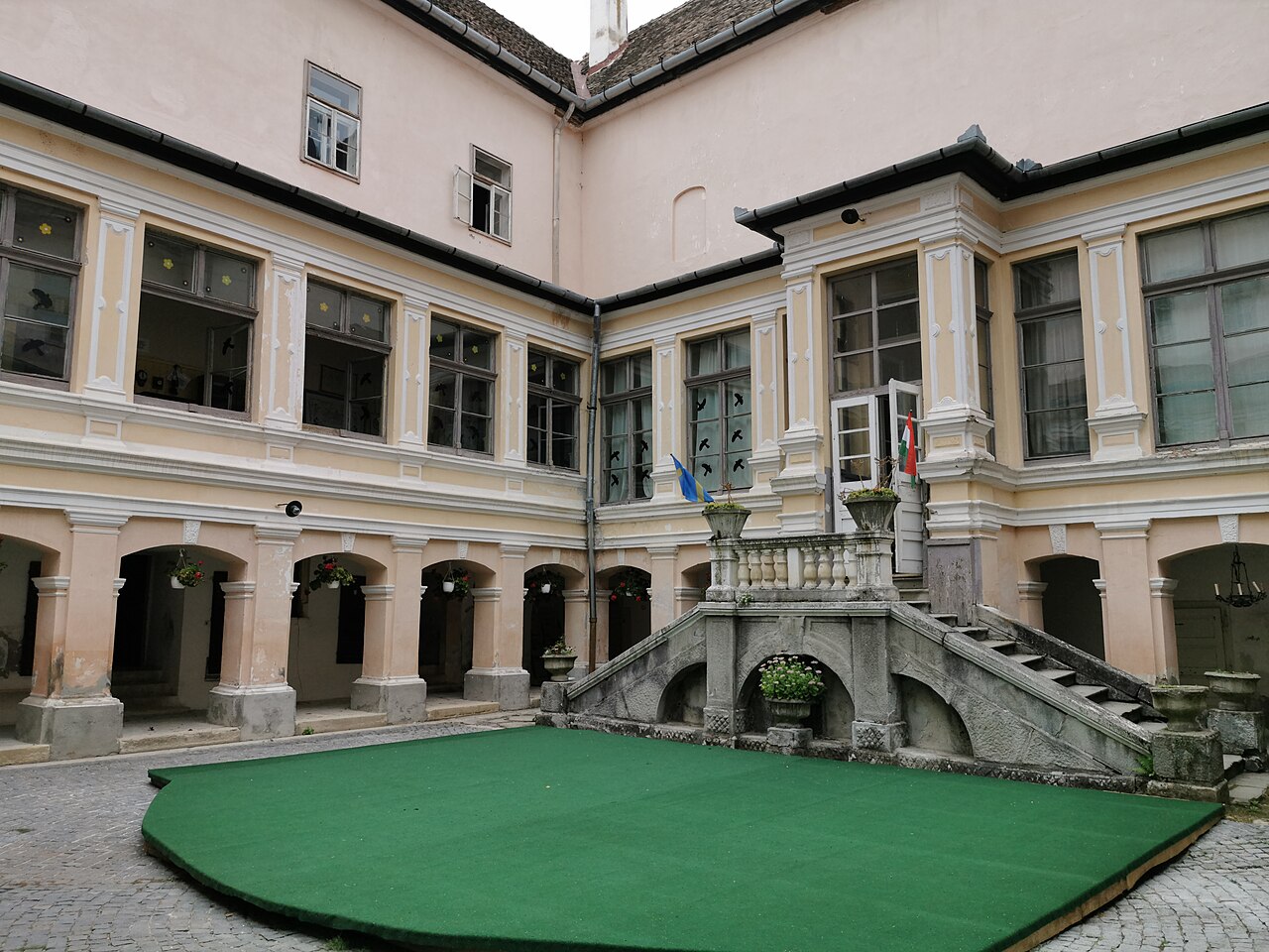 Curtea interioară cu arcade, galerie vitrată și scara monumentală.