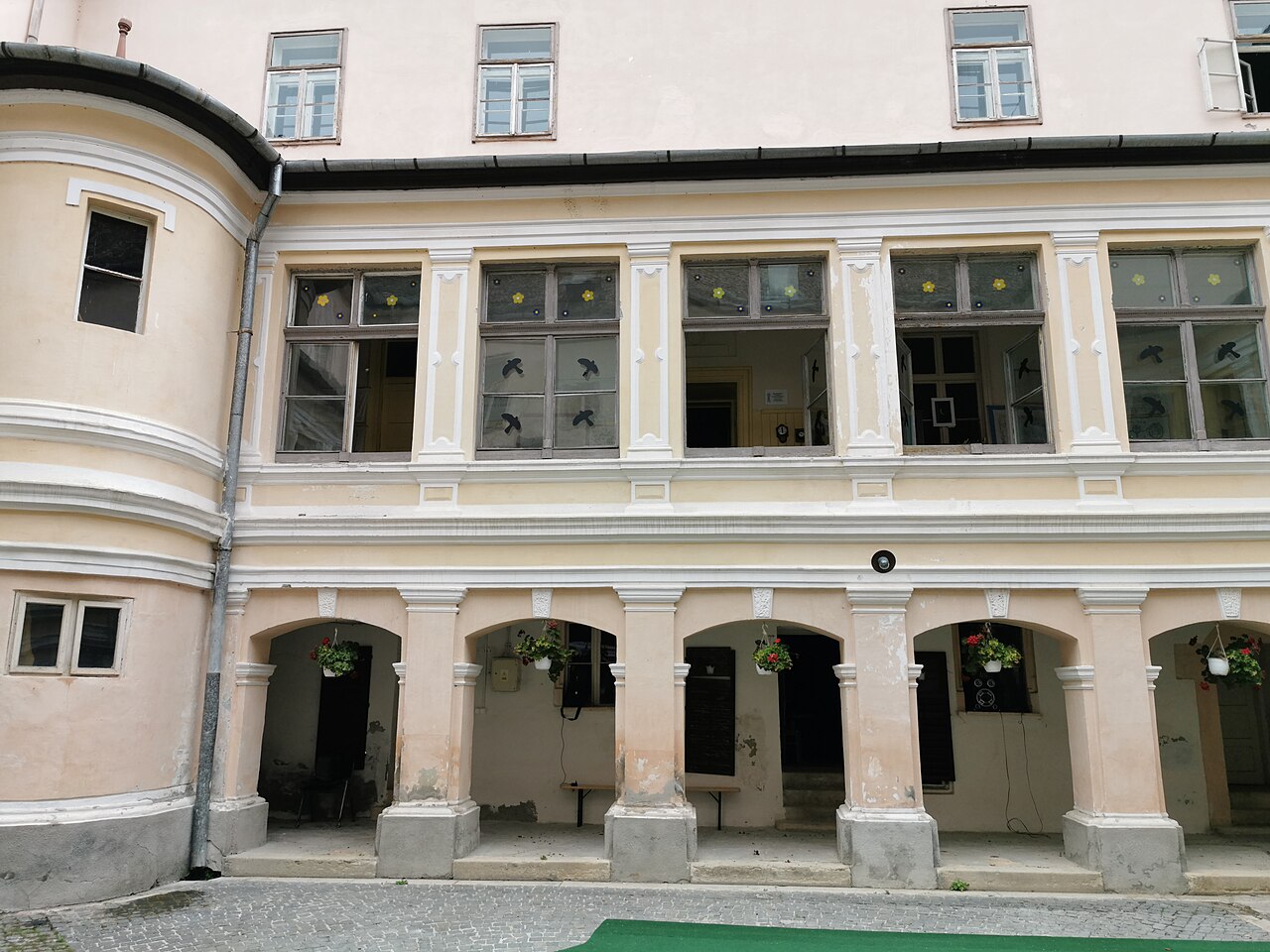 Arcadele parterului și galeria vitrată de deasupra lor.