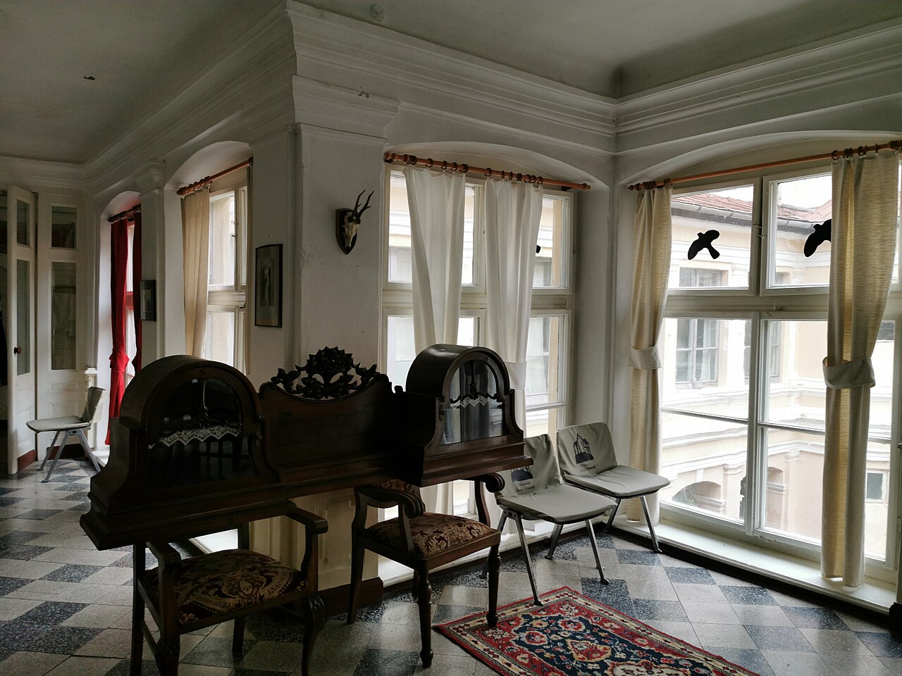 Galerie vitrată, uși și mobilier; iluminare naturală.
