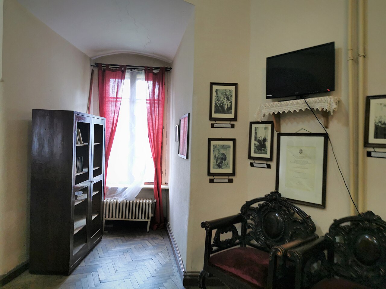 Salonul cu fereastră înaltă, mobilier și profile de perete.