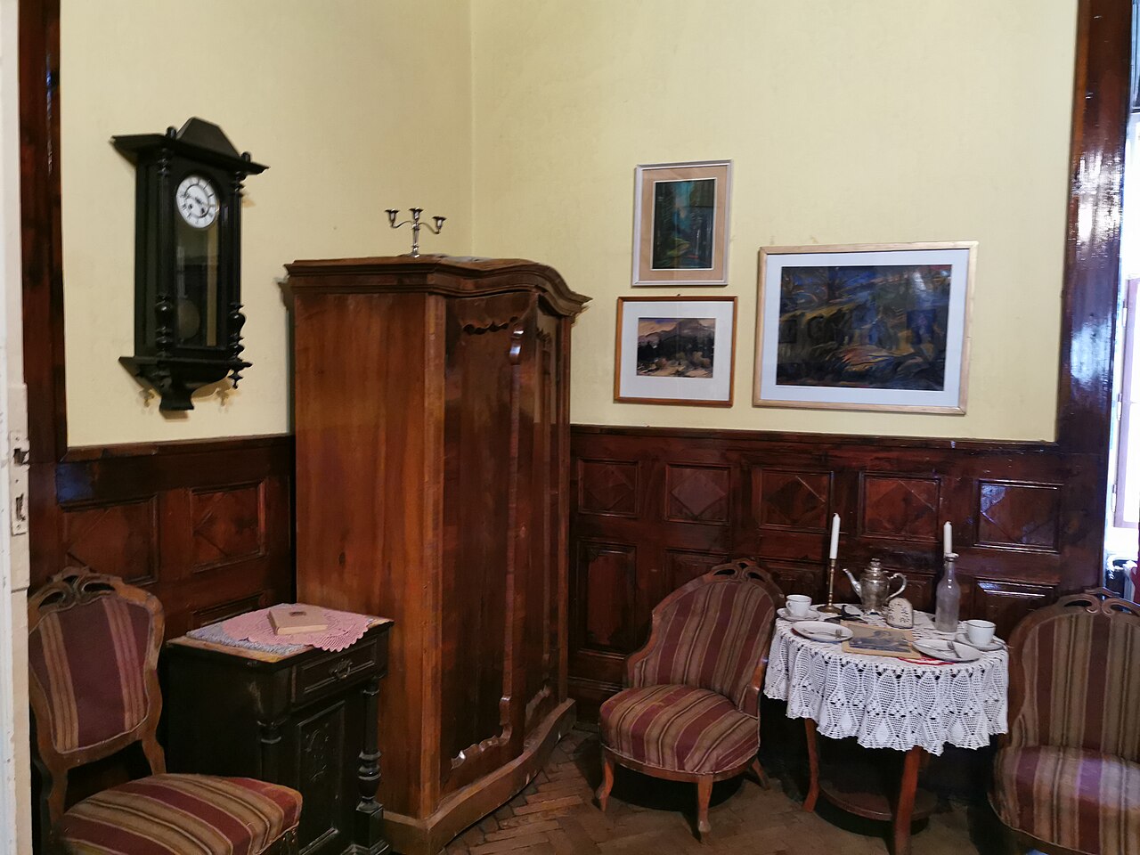 Salon cu lambriu de lemn și ușă.