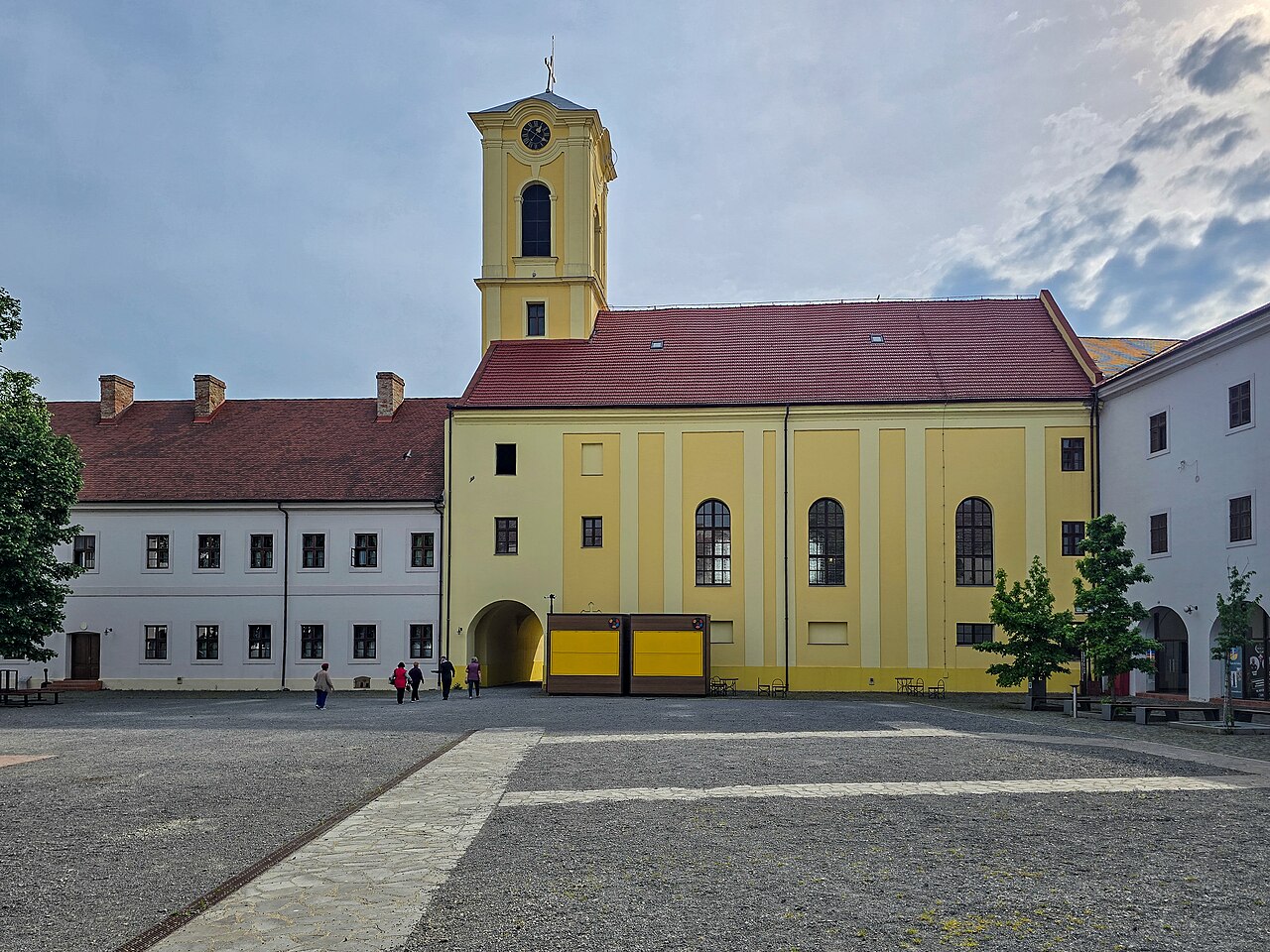 Biserica din curtea interioară, cu turnul galben și fațada laterală.