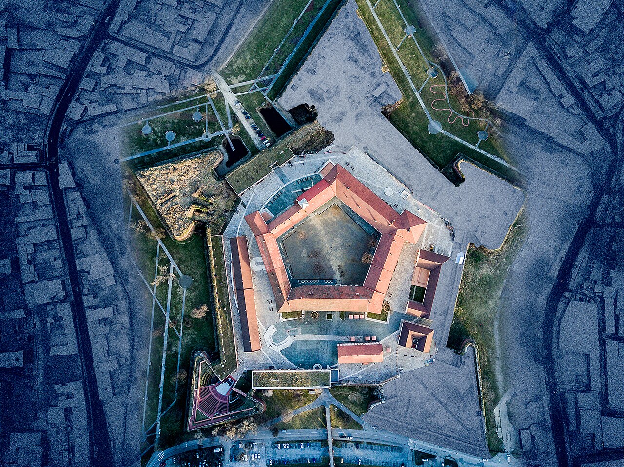 Fotografie aeriană aproape verticală a pentagonului și palatului interior; coloristică accentuată.