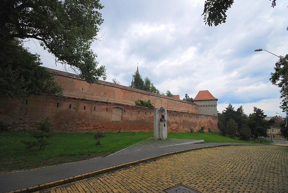 Zidul lung de cărămidă și bastionul din capăt, văzute oblic.