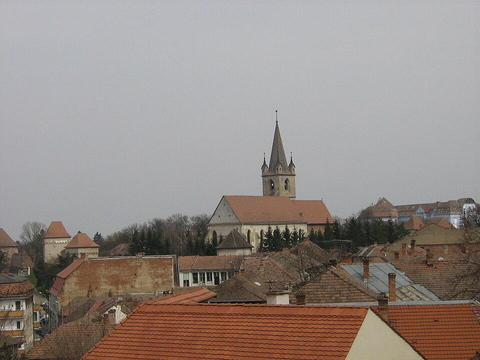 Biserica și zidurile văzute de la un punct înalt din oraș; detaliile incintei sunt mici.