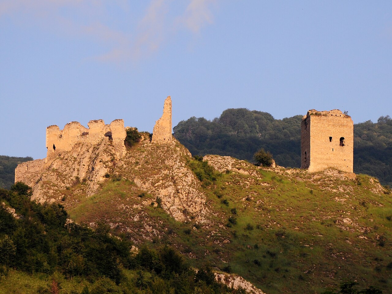 Cetatea de Sus și donjonul, văzute de pe latura opusă în lumină caldă.