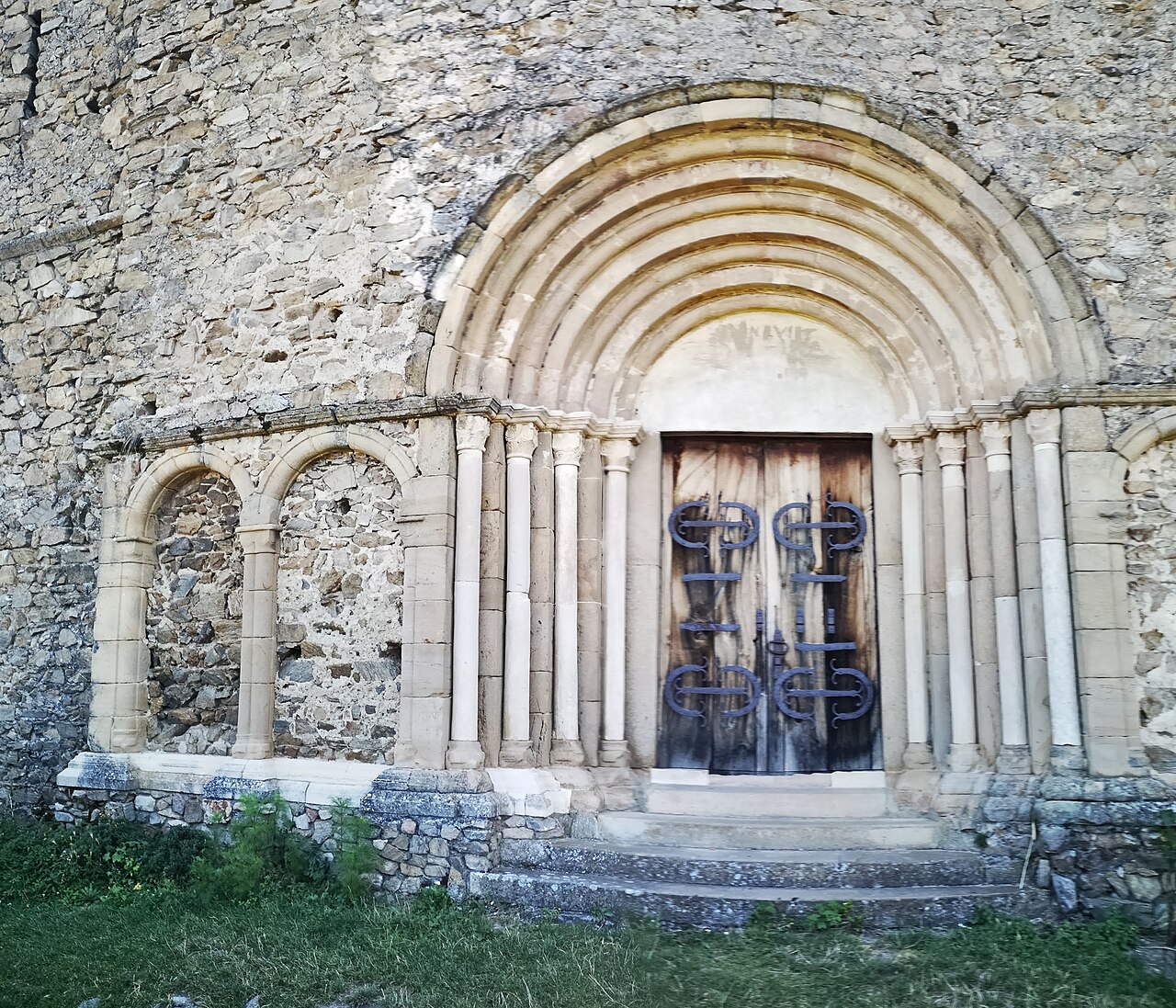 Portalul romanic vestic, cu retrageri concentrice, colonete și arcade laterale.