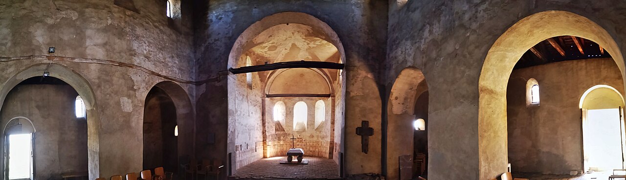 Interior panoramic cu arcadele dintre nave și absida centrală; proiecție deformată.