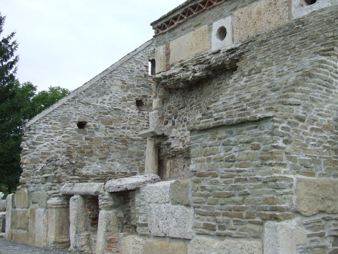 Coloane reutilizate și zidul lateral.