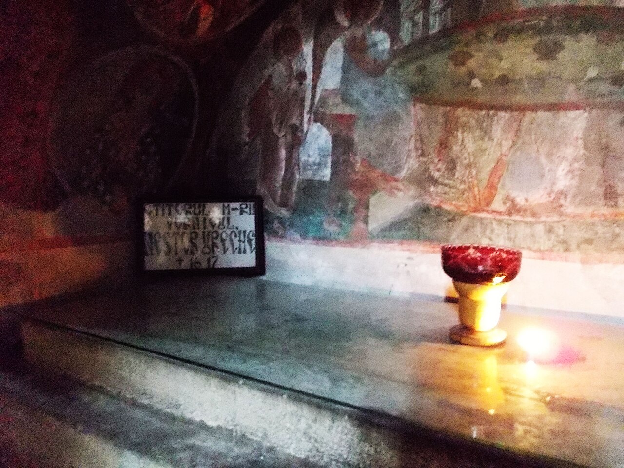 Lespede funerară și perete pictat în interior.