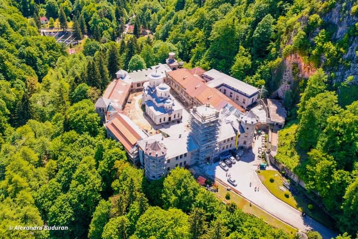 Vedere aeriană oblică: incinta, biserica, acoperișurile și stânca din vecinătate. Incinta prezintă schele de restaurare.