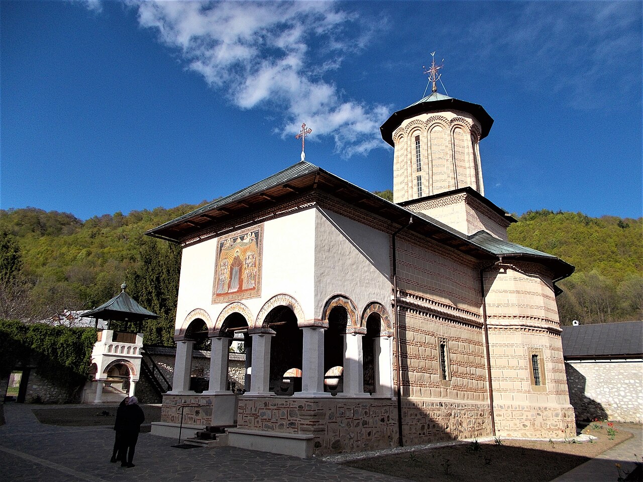 Biserica Adormirea Maicii Domnului: pridvor deschis, turlă și fațadă laterală.