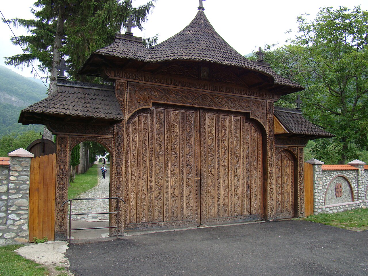 Poarta exterioară de lemn, stâlpi și învelitoare.